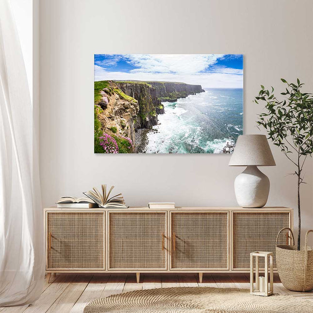 Tolles Wandbild im Wohnzimmer mit Blick auf eine Steilküste und Ozean mit blauem Himmel über einer Rattan Kommode 
