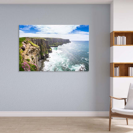 Wandbild mit einem Panoramablick über die Atlantikküste, Steilküste mit grüner Wiese unter blauem Himmel. Perfekt passend in Ihre Leseecke neben dem weißen Sesse.