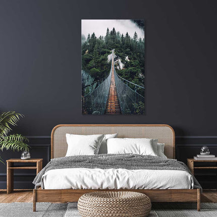 Leinwand Bild als Dekoration im Schlafzimmer. Das Bild zeigt eine Hängebrücke über eine Schlucht. Am Ende der Brücke ist ein sattgrüner Tannenwald im Nebel.
