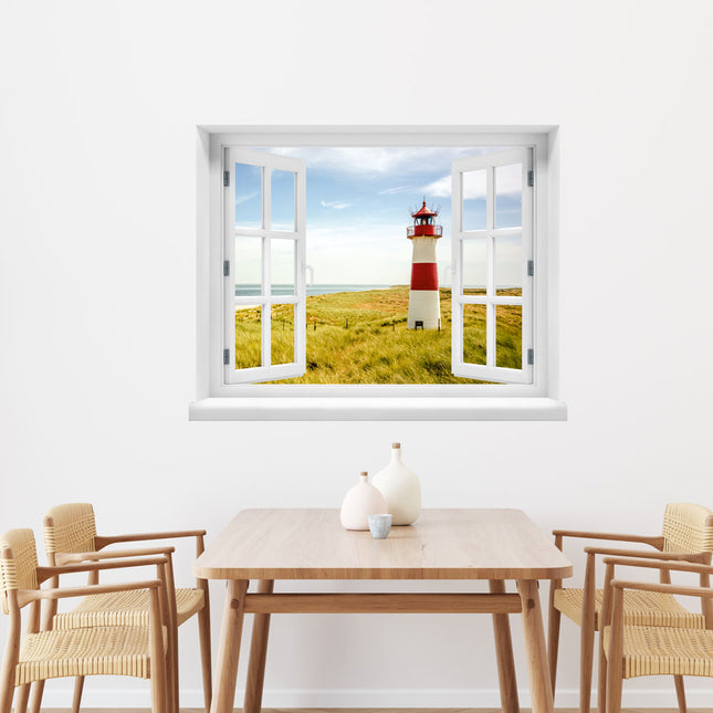 Genieße das sonnige Flair der Ostsee in deinem Zuhause! Fenstermotiv als Wandtattoo mit einer idyllischen Aussicht auf einen Leuchtturm, Dünen und das glitzernde Meer, an der Wand über einem Esstisch. Eine maritime Dekoration für Urlaubsfeeling.