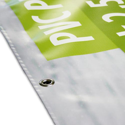 Detailansicht der Ecke eines Werbebanners mit einer Metallöse und grünem Aufdruck, zeigt die präzise Verarbeitung und Qualität, die für den Druckservice von Außenwerbung notwendig ist.