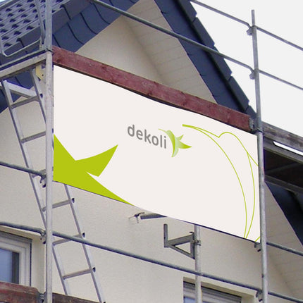 Großflächiges Banner von dekoli, befestigt an einem Baugerüst vor einem Wohnhaus, bietet eine wirkungsvolle Plattform für Außenwerbung und visuelles Marketing, präsentiert von einer Druckerei.