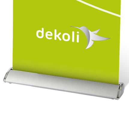 Detailansicht Roller Banner Deluxe, mit stabilem, abgerundetem silbernen Stanfuß. Grüner Banner mit weißem und silbernem Dekoli Logo.