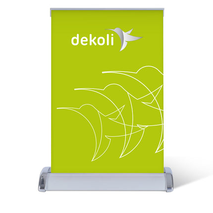 Ein leuchtend grünes dekolli Roll-Up Banner mit weißem Logo, präsentiert auf einem silbernen Tischständer für auffällige Point-of-Sale Werbung.