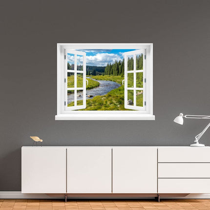 Verwandeln Sie Ihre Wand in ein Fenster zur Natur! Selbstklebendes Wandbild mit realistischem Fenstermotiv, das eine entspannende Aussicht auf eine grüne Berglandschaft mit Fluss bietet, an einer grauen Wand, über einer weißen Kommode im Flur. Die perfekte Dekoration für eine kleine Flucht aus dem Alltag.
