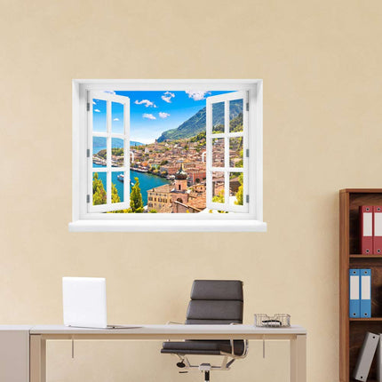Erwecken Sie den Zauber von Limone sul Garda in Ihrem Büro! Wandaufkleber in Form eines Fensters, platziert über einem Schreibtisch, enthüllt die Schönheit des berühmten Hafens am Gardasee, wo die Sonne über dem Meer und dem malerischen Dorf strahlt. Perfekt für eine faszinierende Dekoration und Kurzurlaubsgefühle am Arbeitsplatz.