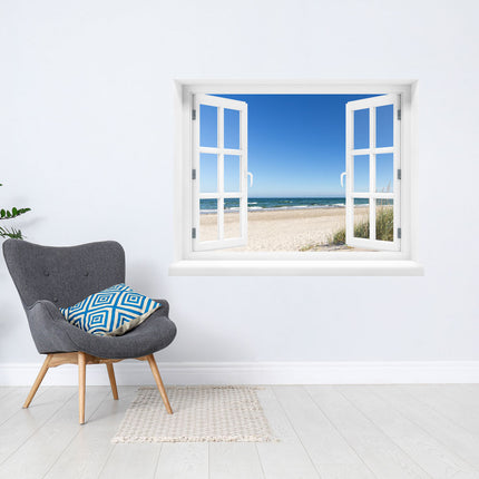 Hol dir den Meereszauber in dein Zuhause! Selbstklebendes Wandbild in Form eines geöffneten, weißen Fensters mit beruhigender Aussicht auf den sonnigen Ostseestrand, das glitzernde Meer und die sanften Wellen unter einem strahlend blauen Himmel, als Deko in einer Leseecke. Perfekt für das Gefühl von Urlaub und Entspannung.