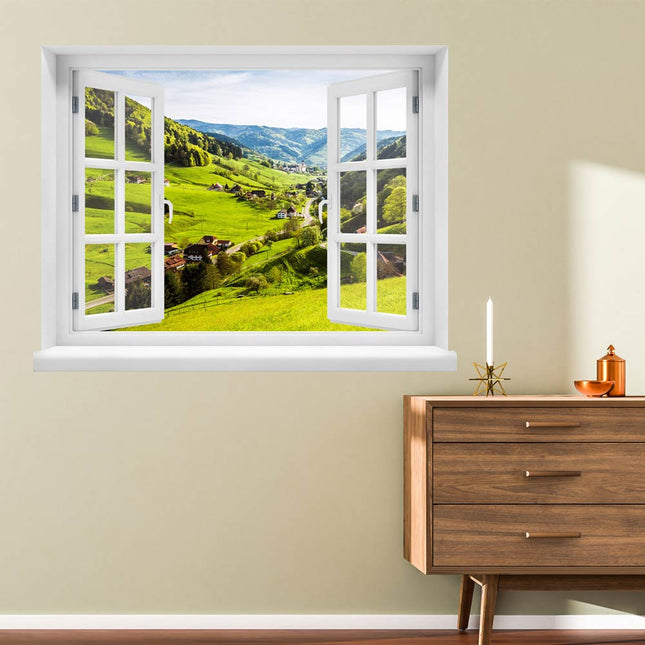 Bringen Sie die idyllische Atmosphäre des Schwarzwaldes in Ihr Zuhause! Wandaufkleber in Fensterform mit Blick auf ein Tal mit Wohnhäusern, eingebettet in die malerische Landschaft im Sonnenschein, platziert neben einer Kommode im Flur. Eine schöne Illusion für verträumte Momente.